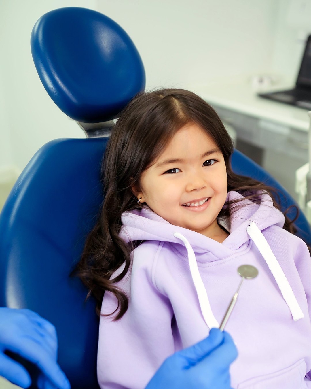 A smiling young girl in a dental chair at her check-up.